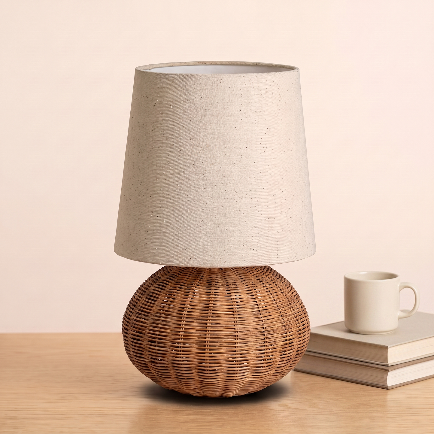Braxton Rattan Table Lamp beside books and a mug to show its size