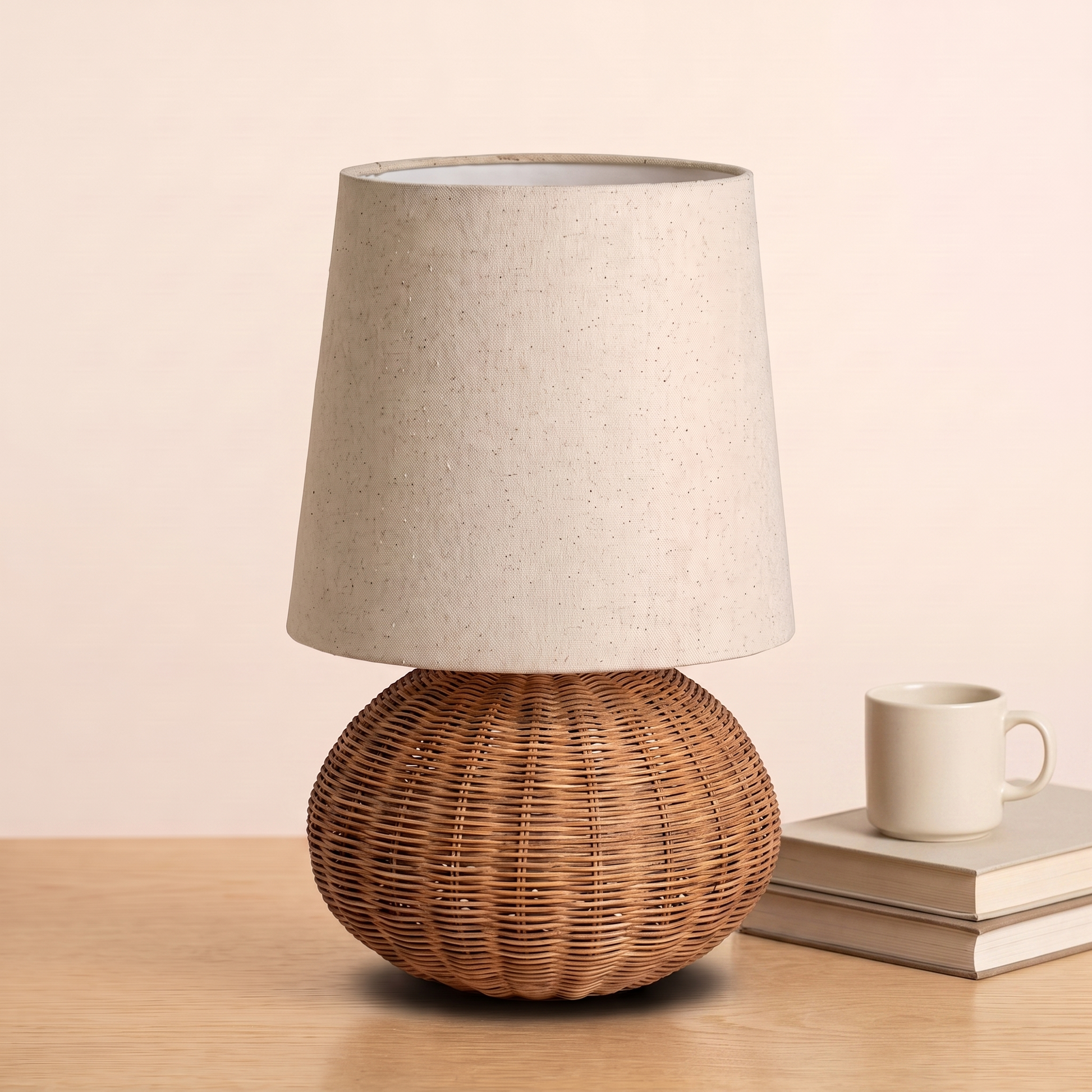 Braxton Rattan Table Lamp beside books and a mug to show its size