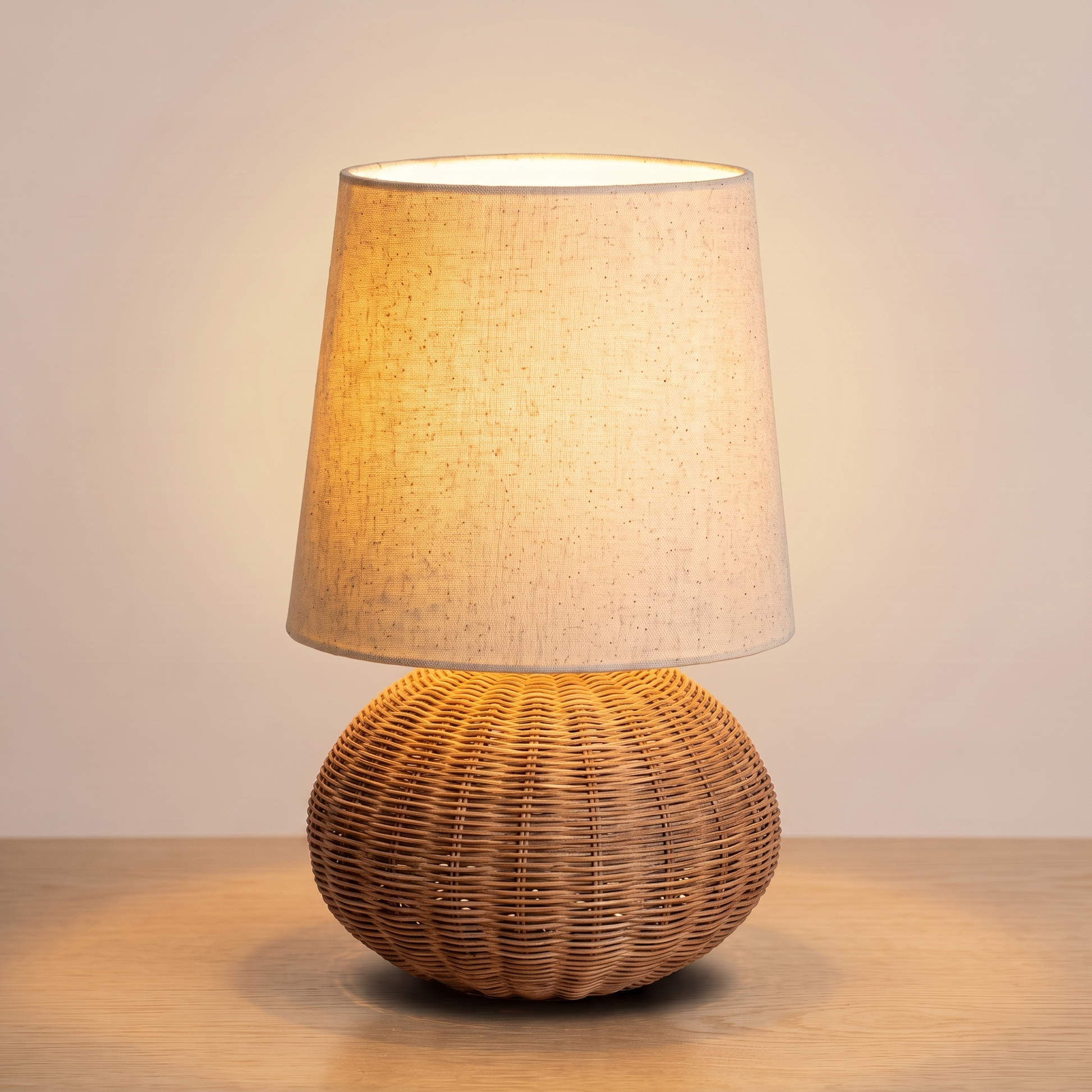 Braxton Rattan Table Lamp switched on with a warm glow