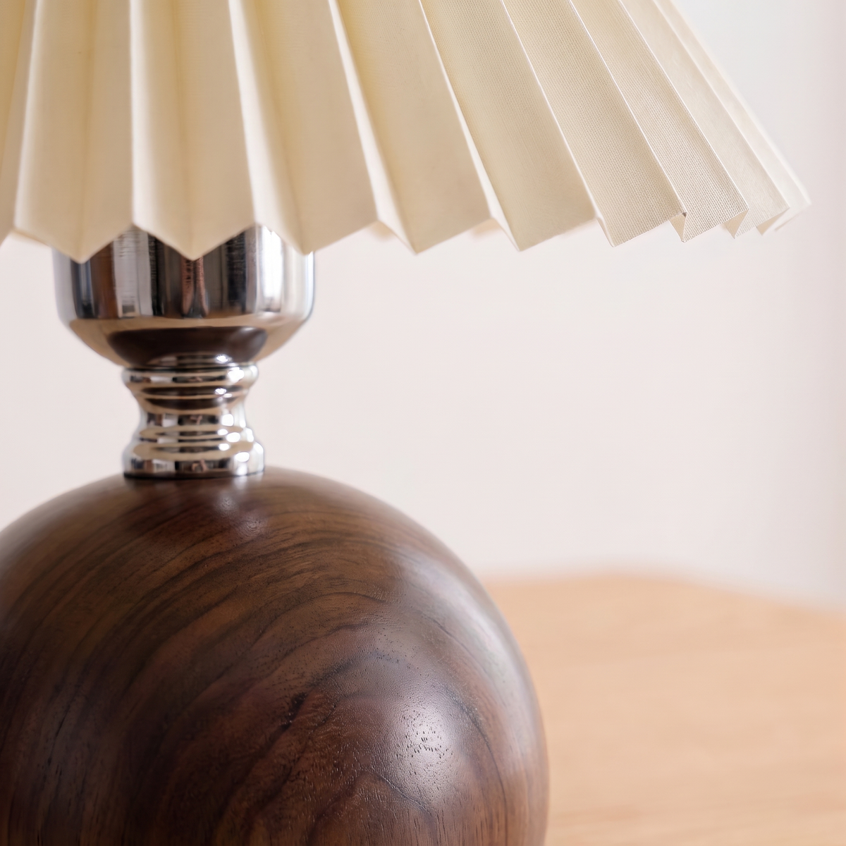 Close up of the walnut wood base and the pleated shade edge