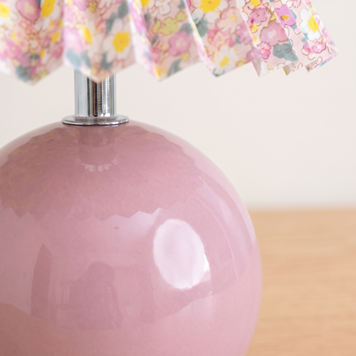 Close up of the pink glazed ceramic base and the pleated shade edge